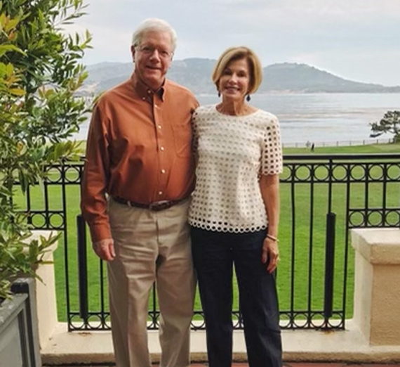 卒業帽とローブを着た女性がカメラに微笑む